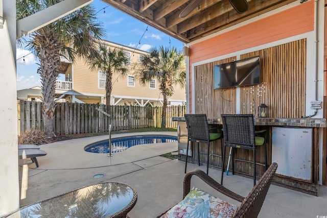 view of swimming pool featuring outdoor dry bar, a patio area, a fenced backyard, and a fenced in pool