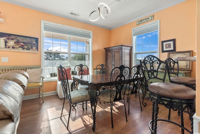 dining space with ornamental molding, visible vents, baseboards, and wood finished floors