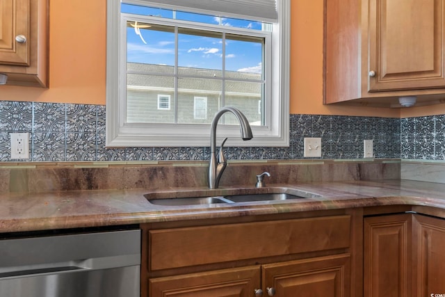 kitchen featuring a sink, brown cabinets, decorative backsplash, and stainless steel dishwasher