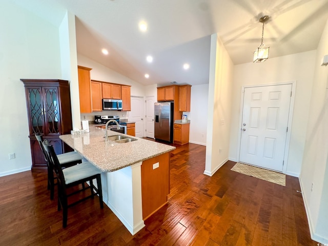 kitchen featuring sink, stainless steel appliances, dark hardwood / wood-style floors, light stone countertops, and kitchen peninsula