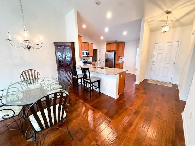 kitchen featuring pendant lighting, sink, an inviting chandelier, stainless steel appliances, and dark hardwood / wood-style flooring