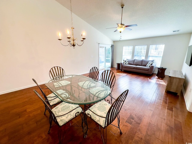 dining area with lofted ceiling, ceiling fan with notable chandelier, dark hardwood / wood-style floors, and a textured ceiling