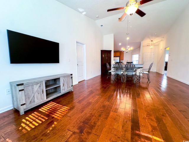 interior space with dark hardwood / wood-style floors, ceiling fan with notable chandelier, and high vaulted ceiling