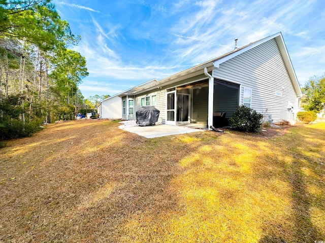 rear view of house featuring a patio and a yard