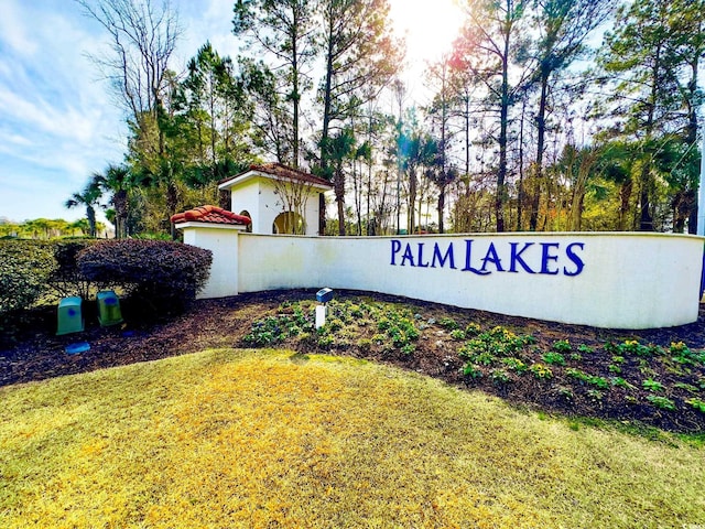 community / neighborhood sign featuring a lawn