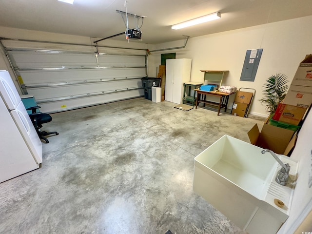 garage featuring a garage door opener, electric panel, sink, and white fridge