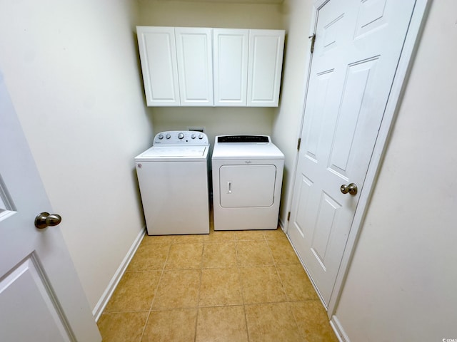 washroom with washer and dryer, light tile patterned floors, and cabinets