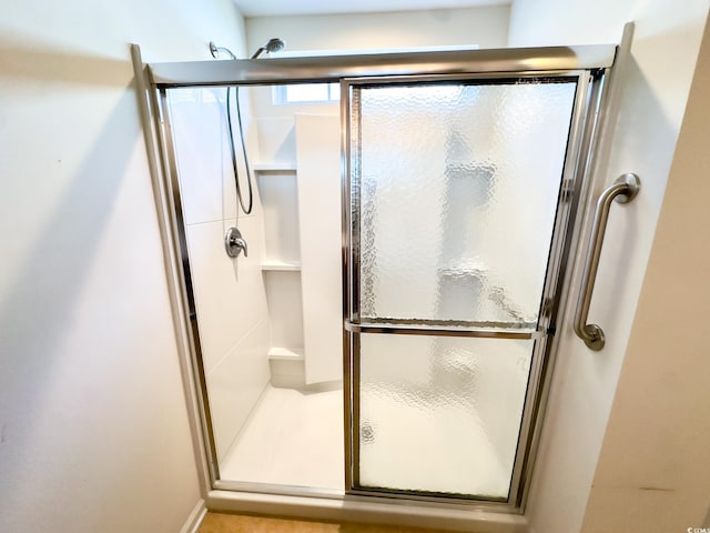 bathroom with a shower with door