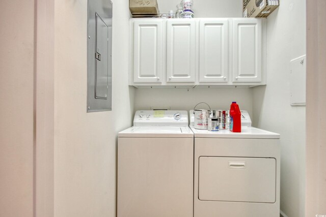 washroom featuring cabinets, electric panel, and washer and clothes dryer