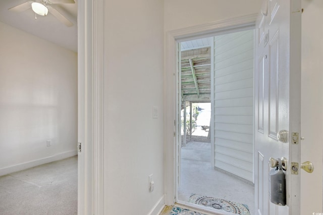 doorway to outside with light carpet and ceiling fan