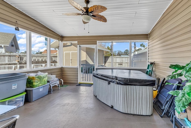 sunroom featuring ceiling fan, a healthy amount of sunlight, and a jacuzzi