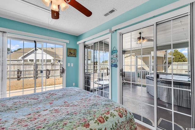 bedroom featuring access to exterior, a textured ceiling, and ceiling fan