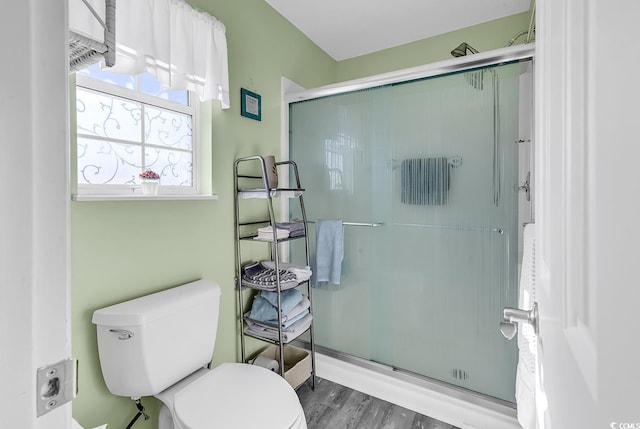 bathroom featuring walk in shower, wood-type flooring, and toilet