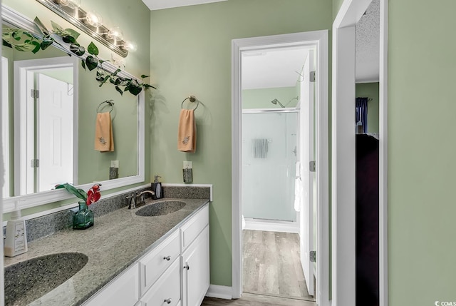 bathroom featuring vanity, hardwood / wood-style flooring, and a shower with door