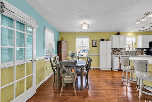 dining room featuring dark hardwood / wood-style floors, sink, and a textured ceiling