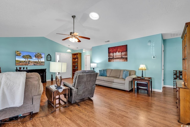 living room featuring hardwood / wood-style flooring, lofted ceiling, and ceiling fan