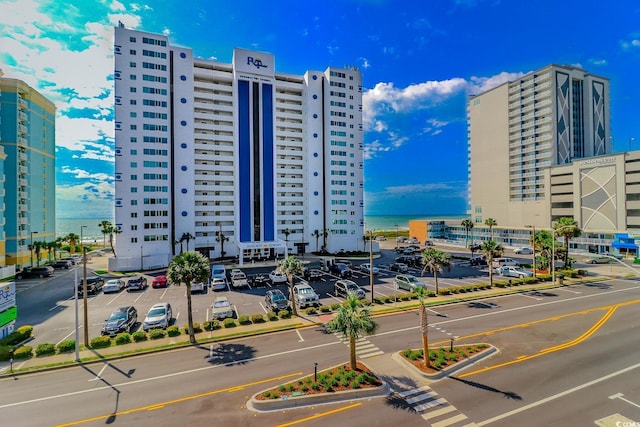 view of property with uncovered parking and a view of city