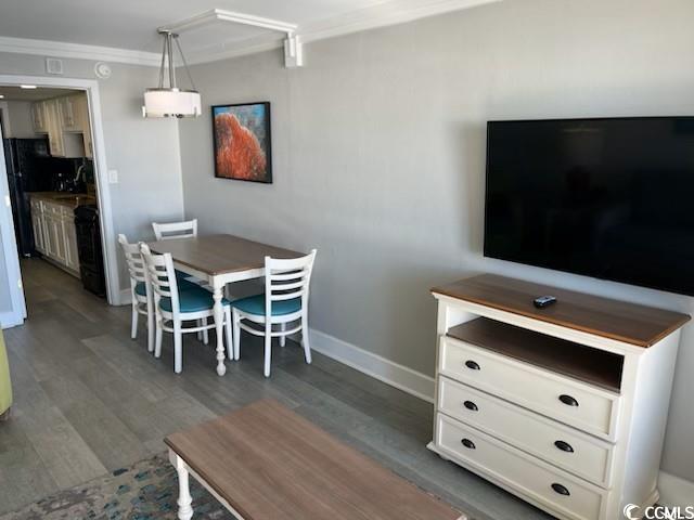 dining space with baseboards, ornamental molding, and wood finished floors