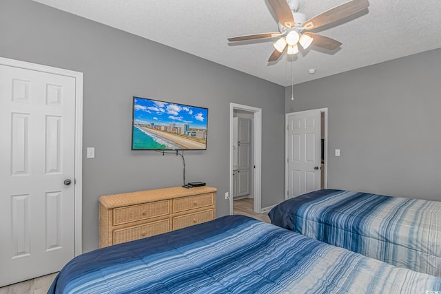 bedroom with ceiling fan and a textured ceiling