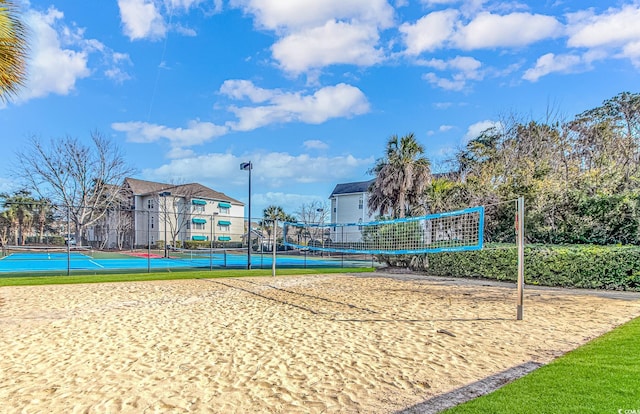 view of home's community featuring a tennis court and fence