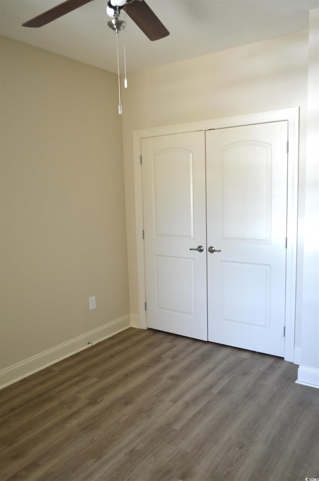 81 Delray Dr Unit 2-C, Murrells Inlet, SC 29576 - unfurnished bedroom featuring dark wood-style flooring, baseboards, a ceiling fan, and a closet