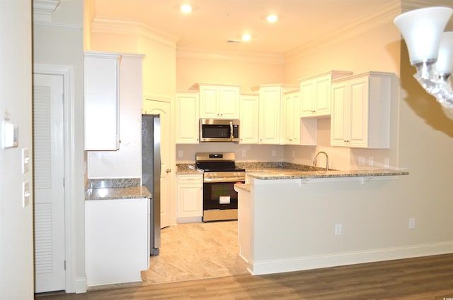 81 Delray Dr Unit 2-C, Murrells Inlet, SC 29576 - kitchen with appliances with stainless steel finishes, a peninsula, a kitchen breakfast bar, light stone countertops, and light wood-style floors