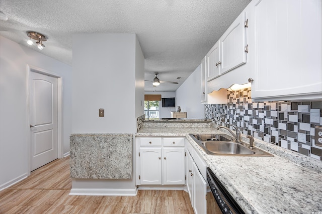 kitchen featuring dishwasher, white cabinetry, sink, decorative backsplash, and light wood-type flooring