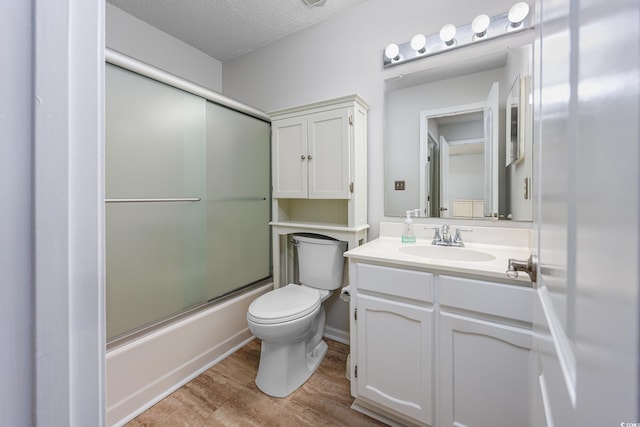 full bathroom featuring hardwood / wood-style floors, enclosed tub / shower combo, vanity, toilet, and a textured ceiling