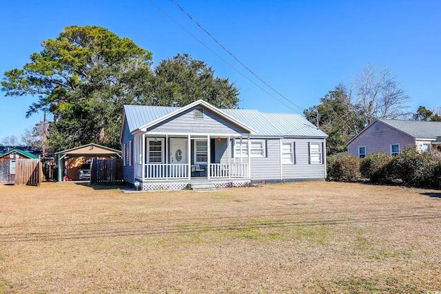 view of front of property featuring a porch, a front yard, and a carport