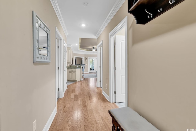 hall with ornamental molding and light hardwood / wood-style floors