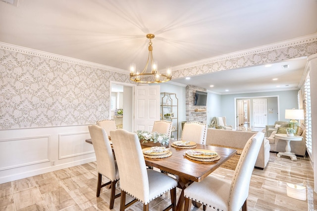 dining area with ornamental molding, a chandelier, and light wood-type flooring