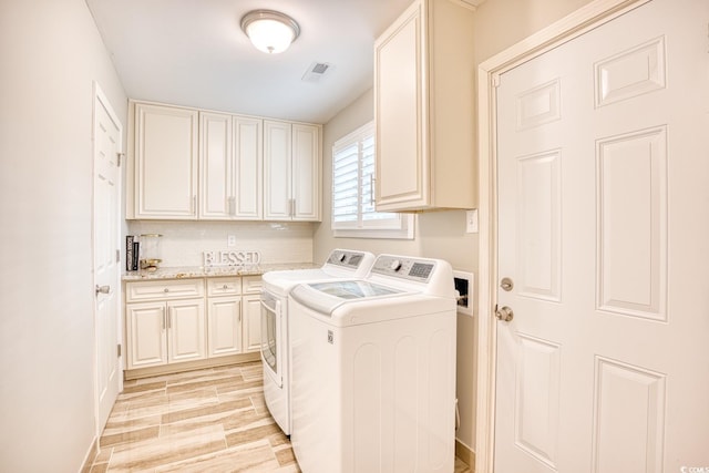 washroom featuring cabinets and washer and dryer