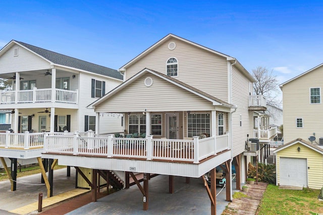 back of house featuring cooling unit, a garage, an outdoor structure, and ceiling fan