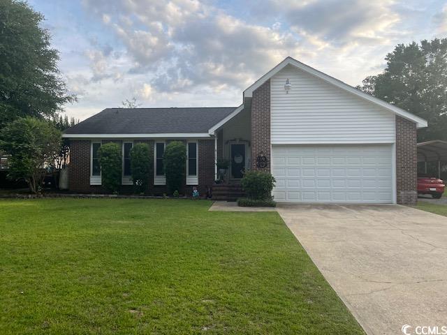 single story home featuring a garage, a carport, and a front yard