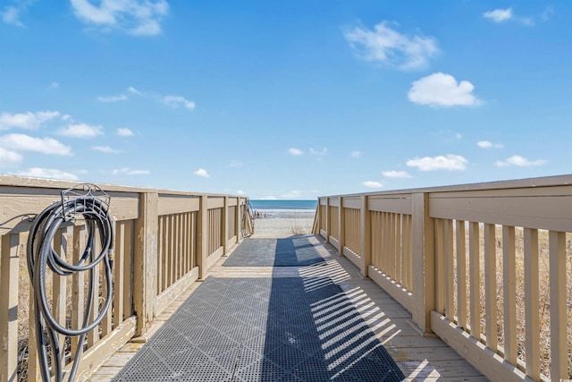 view of home's community with a deck with water view and a view of the beach