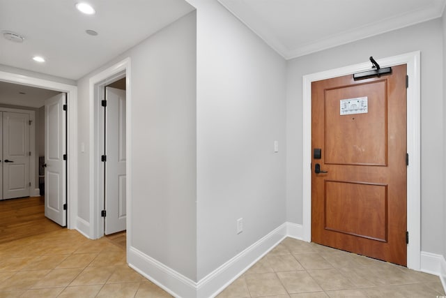 entrance foyer with light tile patterned floors and crown molding