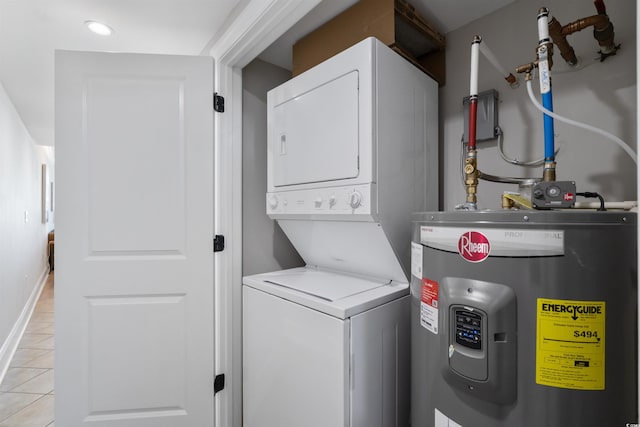 laundry room featuring water heater, stacked washing maching and dryer, and light tile patterned floors