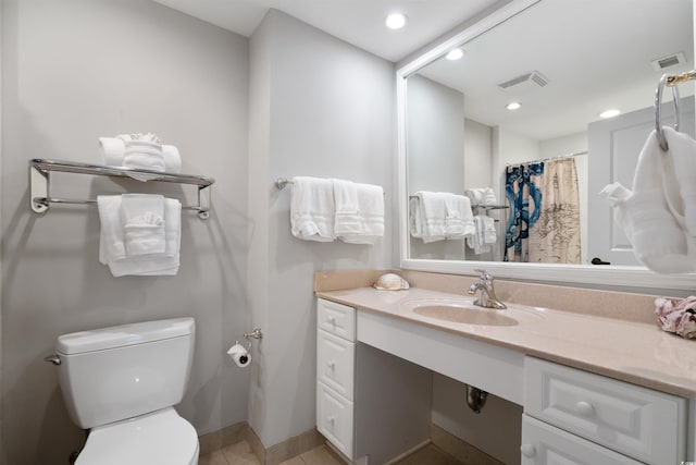 bathroom featuring vanity, tile patterned floors, toilet, and walk in shower