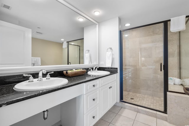 bathroom with an enclosed shower, vanity, and tile patterned floors