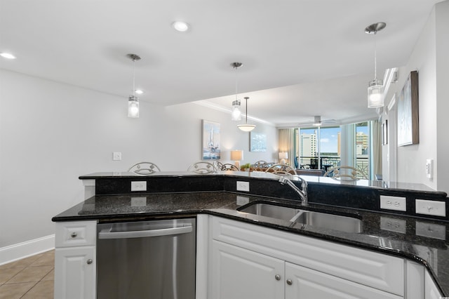 kitchen with white cabinetry, sink, stainless steel dishwasher, and dark stone counters