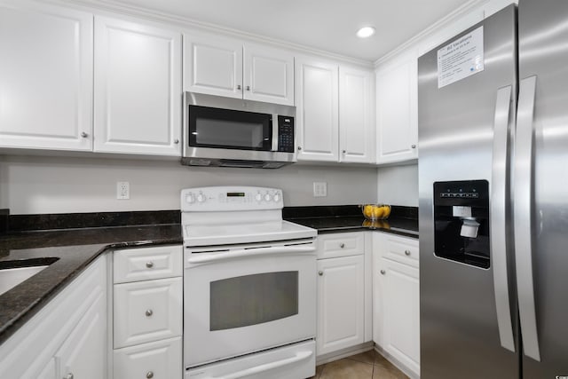 kitchen featuring white cabinetry, light tile patterned floors, dark stone counters, and appliances with stainless steel finishes