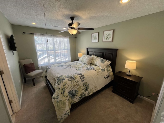 bedroom with ceiling fan, a textured ceiling, and dark colored carpet