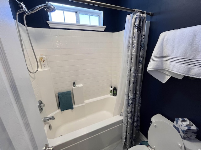 bathroom featuring shower / bath combination with curtain and toilet