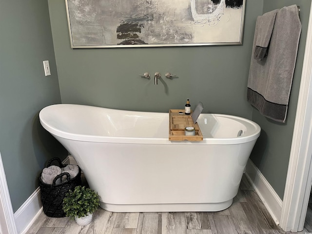 bathroom with hardwood / wood-style flooring and a washtub