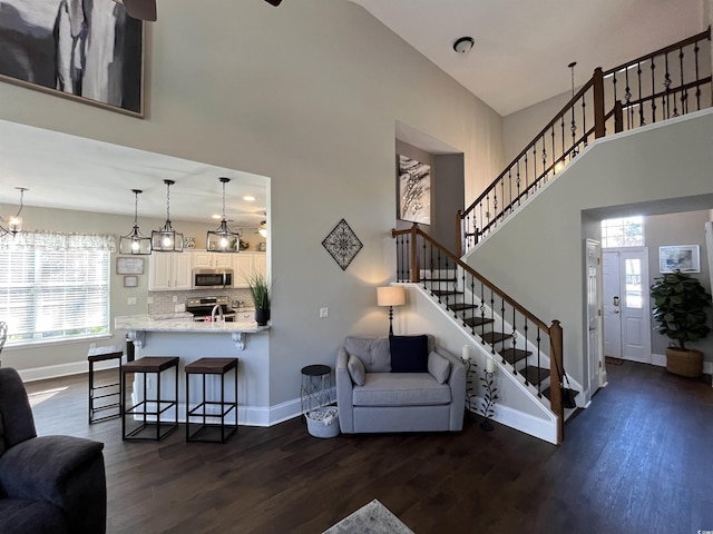 living room featuring sink, dark wood-type flooring, and a high ceiling