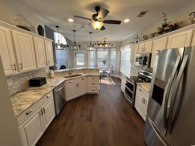 kitchen featuring sink, hanging light fixtures, stainless steel appliances, white cabinets, and kitchen peninsula