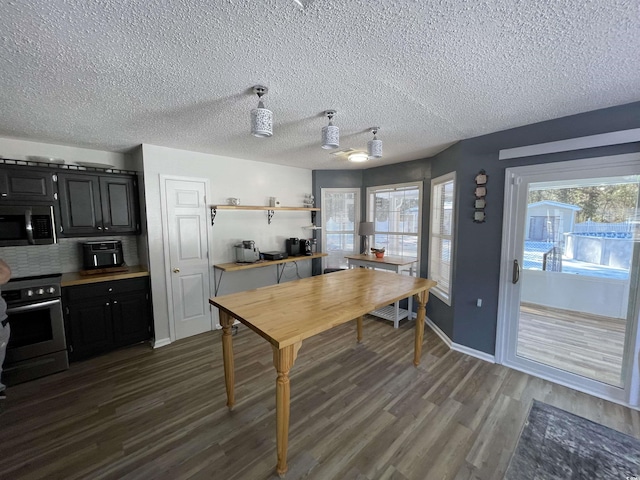 kitchen featuring appliances with stainless steel finishes, dark hardwood / wood-style floors, backsplash, and a textured ceiling