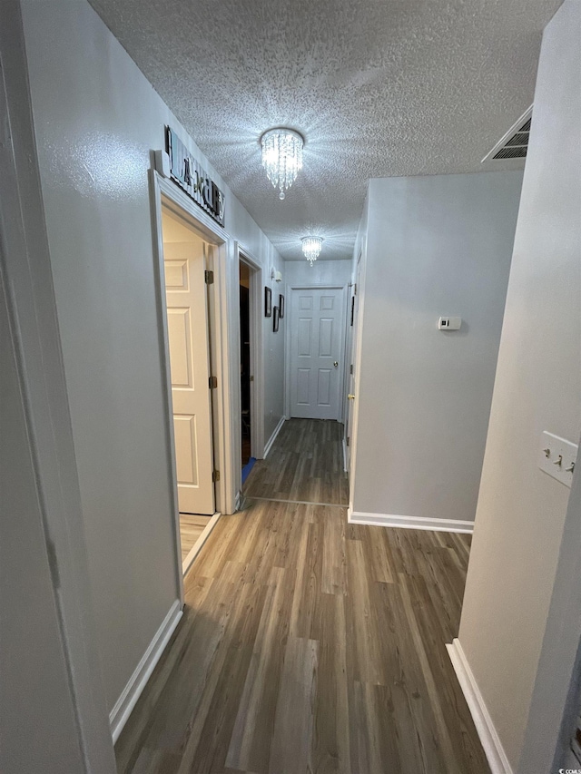 hall with dark hardwood / wood-style floors and a textured ceiling