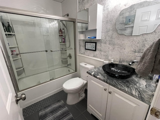 full bathroom with vanity, tile patterned floors, shower / bath combination with glass door, and toilet