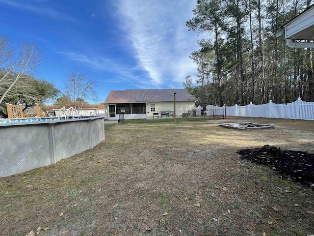 view of yard with a fenced in pool and a sunroom